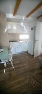 沃迪切Mobile home Ivan Vodice的厨房配有绿桌和白色冰箱。