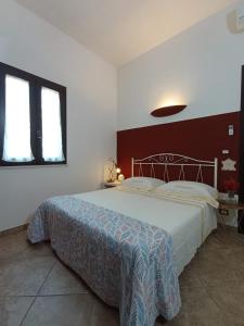 奥特朗托Tenuta I Quattro Venti的一间卧室设有一张大床和两个窗户。