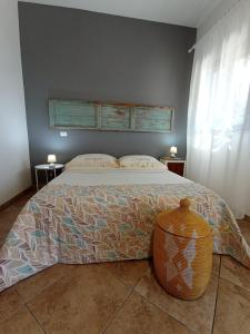 奥特朗托Tenuta I Quattro Venti的卧室配有一张大床,地板上设有锅