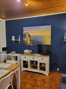 马纳罗拉Casa LA MARINA的一间设有蓝色墙壁、电视和桌子的客房