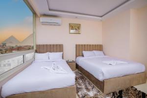开罗Mak Pyramids View的酒店客房设有两张床和窗户。
