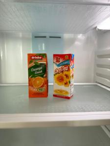 新山E Life D Summit Residences With Wifi & Netflix的空冰箱里装有两盒橙汁和橙薯片