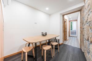 波尔图GuestReady - Bright Duplex in Downtown的一间带木桌和凳子的用餐室