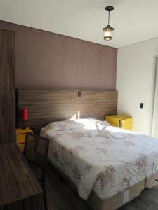坎波斯杜若尔当金色森林普萨达酒店的一间卧室配有一张大床和木制床头板