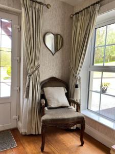 多尼戈尔The Lodge Donegal Town的配有窗帘和镜子的椅子
