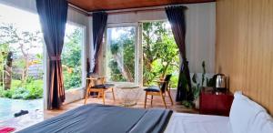 大叻Nature Homes Đà Lạt的一间卧室设有一张床和一个大窗户