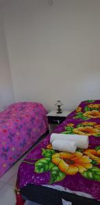 梅赛德斯Departamento en el centro de la ciudad的一张床上,上面有鲜花,上面有紫色毯子