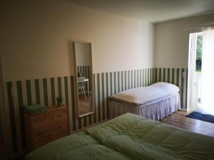 TranekærPension Skovly的一间卧室设有两张床、镜子和窗户