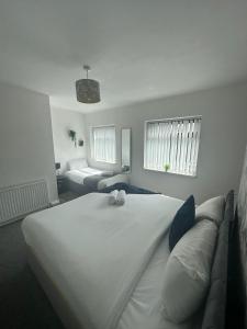 沃灵顿Charming 2-BR Property - Sleeps 5的卧室配有一张白色的大床和一张沙发。