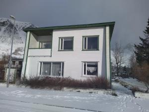 FlateyriFlateyri guesthouse的雪地里带窗户的白色房子