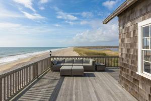 Wakefield6.5-Acre Oceanfront Estate的一个带沙发的甲板,享有海滩美景