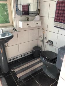 阿雷格里港Casa Moinhos de Vento Vintage的浴室设有黑色的卫生间和水槽。