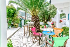 富尔尼群岛帕特斯公寓酒店的一个带五颜六色椅子和棕榈树的庭院