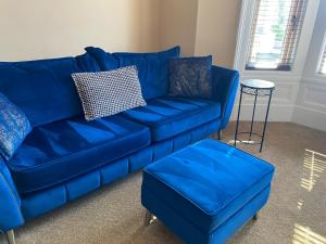 绍斯波特The New Talbot Hotel的客厅里一张蓝色的沙发和搁脚凳