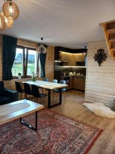 ManiowyDomek na Hubce II的客厅配有桌椅和地毯。
