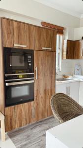 布尔班Swiss Cottage Bhurban的一间带木制橱柜和微波炉的厨房