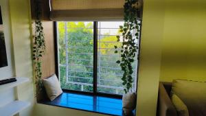 浦那Blue Lagoon的一间窗户的房间,上面有植物