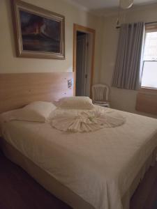 帕萨夸特鲁Pousada Eco Da Montanha的一间卧室配有白色的床,上面有连衣裙