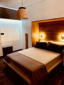 萨摩斯Passatempo Apartment Ireon的一间卧室配有一张大床和木制床头板