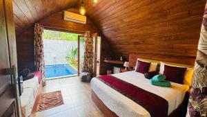 锡吉里亚Palmyra Nature Resort Sigiriya的一间带一张床铺的卧室,位于带游泳池的房间