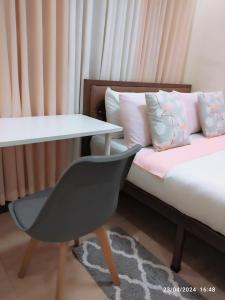 LocsinCasita de Reina Staycation House - A cozy 1-Bedroom condo-style house的客房设有一张带桌子和椅子的床。