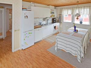 拉霍尔姆Holiday home LAHOLM XIV的厨房配有桌子和白色冰箱。