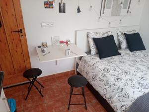 蒙塞拉特Casa Breizh的一间卧室配有一张带桌子和两张凳子的床
