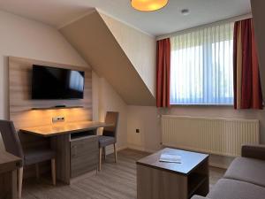 因塞尔波埃尔Appartementanlage Zur Seemöwe的客房设有书桌和平面电视。