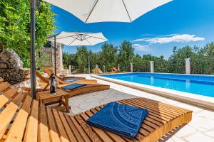 耶塞尼采Betelgeuse的游泳池旁的游泳池配有椅子和遮阳伞