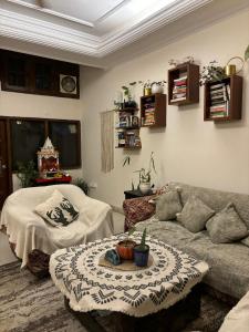 新德里Atharva's Homestay by Goaround Homes的客厅配有沙发和桌子