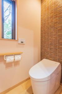 Izumi樱泉会馆的一间带白色卫生间的浴室和窗户。