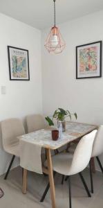 巴科洛德Cosy House in Bacolod City的餐桌,配有白色椅子和盆栽植物