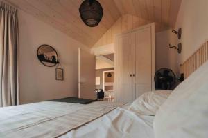 伊皮Fika Tiny House的卧室设有白色的床和木制天花板。