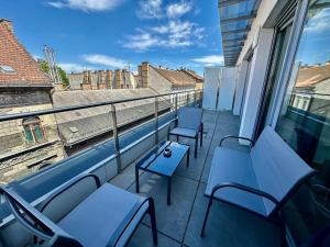 布达佩斯Central Apartment Budapest ~ Roof Terrace/AC/Indoor parking的阳台配有蓝色椅子,享有建筑的景致。