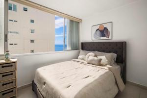 圣胡安Oceanfront Paradise - Spacious and Family Friendly的一间卧室设有一张床和一个大窗户
