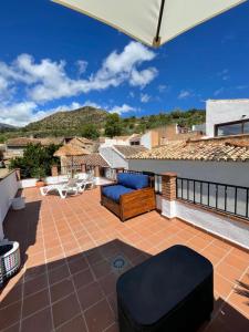 AcequiasCasa Morayma, Lecrin, Granada (Adult Only Small Guesthouse)的屋顶上带椅子和遮阳伞的天井