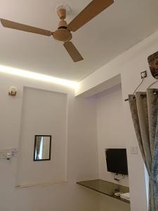 那格浦尔Nakshatra Guest House的配有电脑显示器的客房内的吊扇