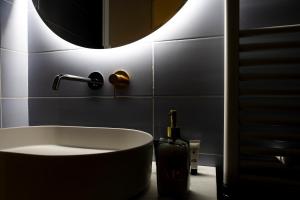 拉奎拉Ginevra Boutique Rooms - Palazzo Leosini - Residenze D'Epoca的带浴缸和圆镜子的浴室
