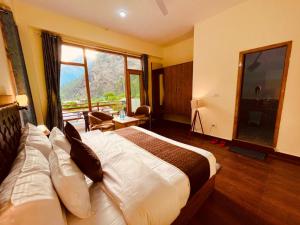 卡索尔Hotel New Panchali With Mountain view By Winterline, Kasol的酒店客房设有一张床和一个大窗户
