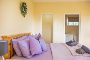 Arnos ValePierocks Highgate Entire house Free Parking and WI-FI的一间卧室配有两张带紫色枕头的床