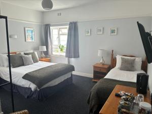 彭赞斯游艇旅馆的酒店客房设有两张床和一张桌子。