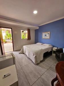 嘎林海斯港Pousada Maldivas di Porto的一间卧室设有一张床和蓝色的墙壁