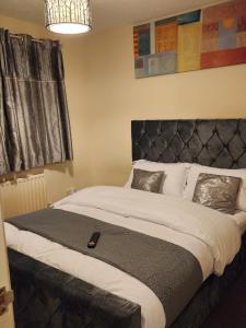 KentCaptivating 3-Bed House in Kent的一间卧室配有一张大床和黑色床头板