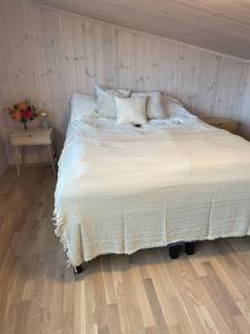 KleppBorestranda - Nytt strandhus med 6 sengeplasser!的卧室内的一张带白色床单和枕头的床