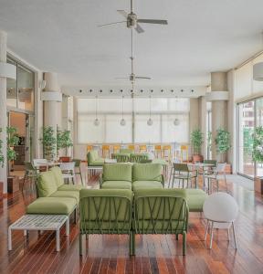 库列拉圣玛尔塔酒店 的大堂设有绿色家具和桌椅。