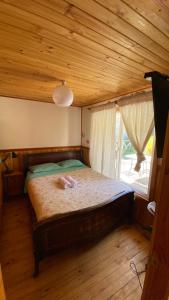 GuayacánCabañas con bajada al río的一间卧室设有一张带木制天花板的大床