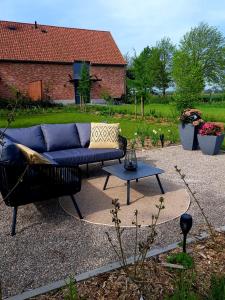 WingeneDe Weldoeninge的院子里的一张蓝色的沙发和一张桌子