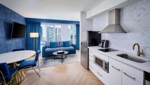 多伦多多伦多中心潘塔基斯酒店的厨房配有水槽和一张带蓝色沙发的桌子