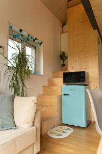 布鲁格Tiny House Chez Claudine with Garden, Workspace, Netflix, free Parking & Wifi的带沙发和冰箱的客厅
