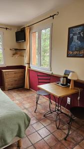 屈屈尼昂奥贝尔格拉塔博乐都库乐酒店的一间卧室配有桌子、床和窗户